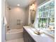Bright bathroom with a combined bathtub and shower, white subway tile, and a vanity with quartz countertop at 3838 Regent Rd, Durham, NC 27707