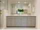 A modern bathroom with double vanity, decorative mirror, and tile shower at 3838 Regent Rd, Durham, NC 27707
