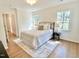 Well-lit bedroom with hardwood floors, a comfortable bed, and lots of natural light from windows at 3838 Regent Rd, Durham, NC 27707