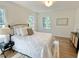 Bright and airy bedroom with hardwood floors, a comfortable bed, and multiple windows offering natural light at 3838 Regent Rd, Durham, NC 27707