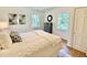 Bright bedroom featuring hardwood floors, a comfortable bed, and plenty of natural light from multiple windows at 3838 Regent Rd, Durham, NC 27707