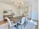 Elegant dining room with a decorative chandelier, hardwood floors, and a view into the kitchen at 3838 Regent Rd, Durham, NC 27707