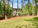 Two story home with a neutral colored brick and surrounded by mature trees at 3838 Regent Rd, Durham, NC 27707