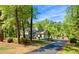Scenic shot of a white two-story home surrounded by mature trees at 3838 Regent Rd, Durham, NC 27707