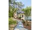 Charming home with neutral colored brick, shutters, mature trees, and a patterned stone walkway at 3838 Regent Rd, Durham, NC 27707