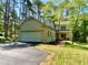 View of home's exterior with side entry garage and mature trees at 3838 Regent Rd, Durham, NC 27707