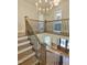 Elegant staircase with iron railings leads to a bright, open foyer with hardwood floors and stylish lighting at 3838 Regent Rd, Durham, NC 27707