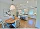 Bright, open kitchen with white cabinets, island, stainless appliances, and adjacent dining area with hardwood flooring at 3838 Regent Rd, Durham, NC 27707