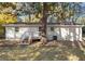 Exterior of the painted brick home with a wooden deck and stairs to the yard at 3907 Inwood Dr, Durham, NC 27705