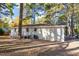 Back of house with a deck and a lawn surrounded by tall trees at 3907 Inwood Dr, Durham, NC 27705