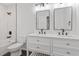 Modern bathroom with dual sinks, white cabinets, and a shower/tub combination at 3907 Inwood Dr, Durham, NC 27705