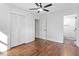 Bright bedroom featuring wood floors, a ceiling fan, closet, and an adjoining bathroom at 3907 Inwood Dr, Durham, NC 27705