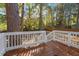 Wooden deck with white railings, providing an outdoor space for relaxing and entertaining amidst a beautiful green backdrop at 3907 Inwood Dr, Durham, NC 27705