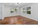 Bright dining room featuring hardwood floors, large windows, and modern light fixture at 3907 Inwood Dr, Durham, NC 27705