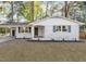 Charming brick home with a covered porch, complemented by dark shutters, fresh landscaping, and a spacious driveway at 3907 Inwood Dr, Durham, NC 27705