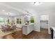 Open-concept living space featuring hardwood floors, a dining area, kitchen island, and access to the laundry room at 3907 Inwood Dr, Durham, NC 27705