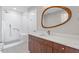 Bright bathroom with white herringbone tile shower, marble countertops, and a unique oval mirror at 400 W North St # 1430, Raleigh, NC 27603