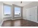 Sunlit bedroom with hardwood floors, large windows, and double door closet at 400 W North St # 1430, Raleigh, NC 27603