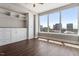 Bright bedroom features a large window with cityscape views, built-in cabinets and wood flooring at 400 W North St # 1430, Raleigh, NC 27603