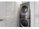 Well-organized laundry room with a silver stacked washer and dryer unit and adjustable white wire shelving at 400 W North St # 1430, Raleigh, NC 27603