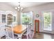 Elegant dining room with a chandelier, a large wooden table, white chairs, and a bright window providing natural light at 420 Cherry St, Fuquay Varina, NC 27526
