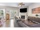 Cozy living room with a fireplace, modern furnishings, a ceiling fan, and wood flooring offering a comfortable living space at 420 Cherry St, Fuquay Varina, NC 27526