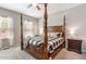 Spacious main bedroom featuring a four-poster bed, carpet flooring, and natural light from the window, creating a cozy retreat at 420 Cherry St, Fuquay Varina, NC 27526