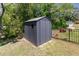 Backyard with black, fenced-in shed with a window, a lawn, and green trees at 420 Cherry St, Fuquay Varina, NC 27526