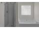 Bright bathroom has a shower and a soaking tub with a frosted glass block window at 4805 Ayden Mill Rd, Apex, NC 27539