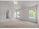 Comfortable bedroom includes a ceiling fan, large windows and an attached bath area at 4805 Ayden Mill Rd, Apex, NC 27539