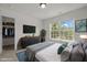 This stylish bedroom includes a closet, a TV, a view overlooking trees, and is filled with soft natural light at 4805 Ayden Mill Rd, Apex, NC 27539
