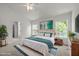 Bright bedroom with white walls, a decorative teal blanket, stylish rug, and natural light streaming through windows at 4805 Ayden Mill Rd, Apex, NC 27539