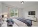 Bright bedroom with a view overlooking trees, a large TV, stylish decor, and soft natural light at 4805 Ayden Mill Rd, Apex, NC 27539