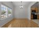 Dining area featuring hardwood floors, kitchen views, and large windows at 4805 Ayden Mill Rd, Apex, NC 27539