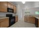 Well-maintained kitchen with wood cabinetry, modern appliances, and tile flooring at 4805 Ayden Mill Rd, Apex, NC 27539