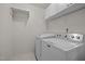 Bright laundry room featuring a Maytag washer and dryer, along with storage shelves and neutral wall paint at 4805 Ayden Mill Rd, Apex, NC 27539