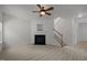 Bright living room with plush carpet, fireplace, and staircase to the second floor at 4805 Ayden Mill Rd, Apex, NC 27539