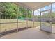 Enclosed patio with screen and view of backyard with lush lawn, trees, and wooden fence at 4805 Ayden Mill Rd, Apex, NC 27539