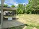 A screened porch with backyard view featuring a lush lawn and scattered trees at 4805 Ayden Mill Rd, Apex, NC 27539
