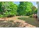 Spacious backyard with a fire pit area, and lush trees offering a peaceful retreat at 4900 American Dr, Durham, NC 27705