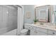 Well-lit bathroom featuring a bathtub, toilet, and a vanity with an updated mirror at 4900 American Dr, Durham, NC 27705
