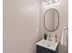Modern powder room featuring a stylish vanity, oval mirror, and contemporary lighting fixtures at 4900 American Dr, Durham, NC 27705