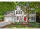 Charming two-story home with a well-manicured lawn and a bright red front door at 4900 American Dr, Durham, NC 27705