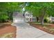 Charming two-story home featuring a gray facade, a red front door, a two-car garage and a spacious concrete driveway at 4900 American Dr, Durham, NC 27705