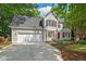 Beautiful two-story home featuring a spacious driveway and lush landscaping at 4900 American Dr, Durham, NC 27705
