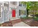 Inviting entryway showcasing a vibrant red door, brick steps, and lush landscaping at 4900 American Dr, Durham, NC 27705