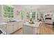 Open-concept kitchen with island flowing into a living room with a fireplace and outdoor views at 4900 American Dr, Durham, NC 27705