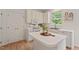 Updated white kitchen boasting modern appliances and an island, complemented by a bright window view at 4900 American Dr, Durham, NC 27705