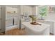 White kitchen featuring island, modern appliances, and a laundry room visible through open double doors at 4900 American Dr, Durham, NC 27705