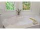 Bright primary bath with corner soaking tub and gold fixtures at 4900 American Dr, Durham, NC 27705
